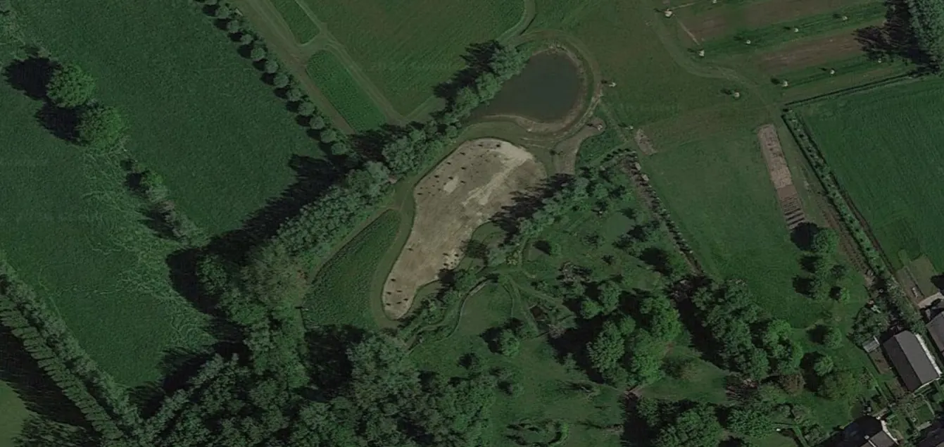 Luchtfoto van een landschapsontwerp: vijver, open weide, bomenrijen en paden